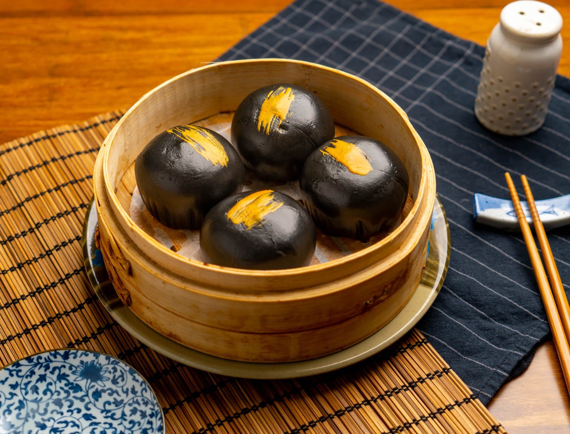Black & Golden Molten Lava Bun - Soft steamed buns with a striking black and golden exterior, filled with a lusci | Dessert